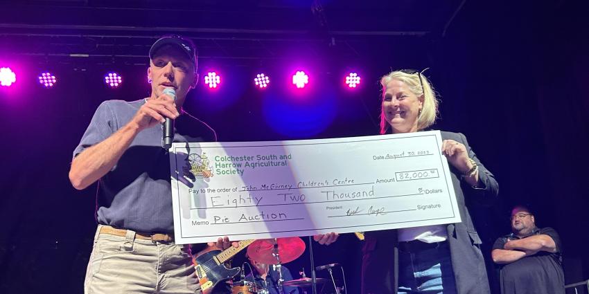 Mark Stannard, Jennifer Jovanovski holding cheque from Harrow Fair Pie Auction