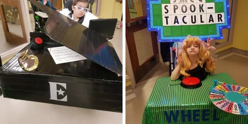 Two children in costume with a piano prop and a game wheel at a Spook-tacular event.