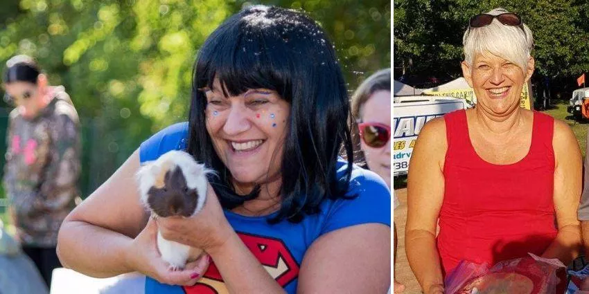 Two women smiling; one in a blue Superman shirt holding a guinea pig, the other in a red sleeveless top outdoors.