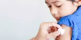 Child receiving vaccine injection in upper arm from healthcare professional.