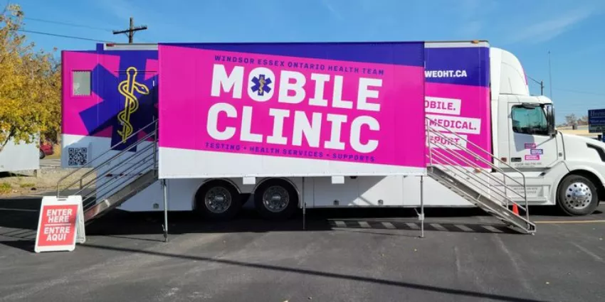 Mobile Clinic truck by Windsor Essex Ontario Health Team with stairs and bilingual entry sign.