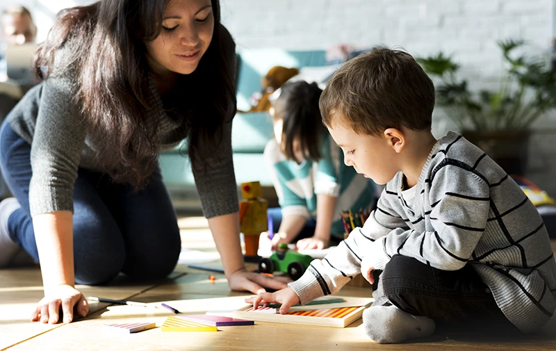 Mom on the floor with her two children playing