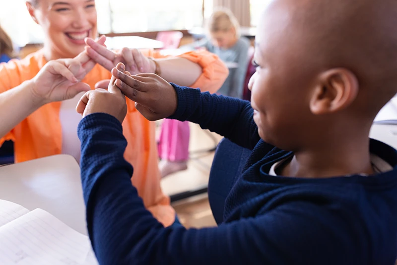 Teacher and boy using sign language