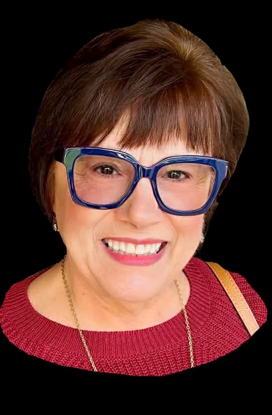 Smiling woman with short brown hair, blue glasses, red sweater, gold necklace against black background